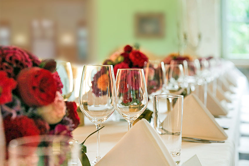 Landhaus Strausberg – gedeckte Hochzeitstafel mit Weingläsern und Blumendekor